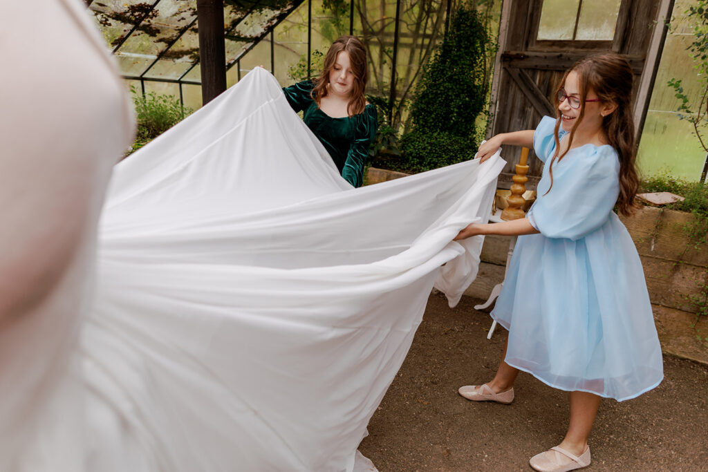 girls fluffing the brides dress
